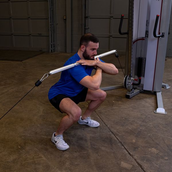 Man Squatting Using The Body-Solid Aluminum Double Swivel Bar