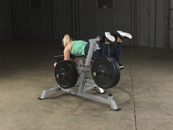 Woman Using Body Solid Leverage Leg Curl